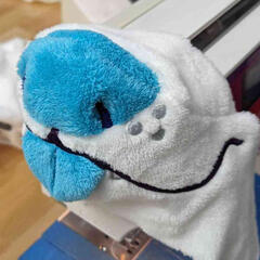 A photograph of the machine embroidered mouth and nose of a plush dog that has not been attached to the head yet.
